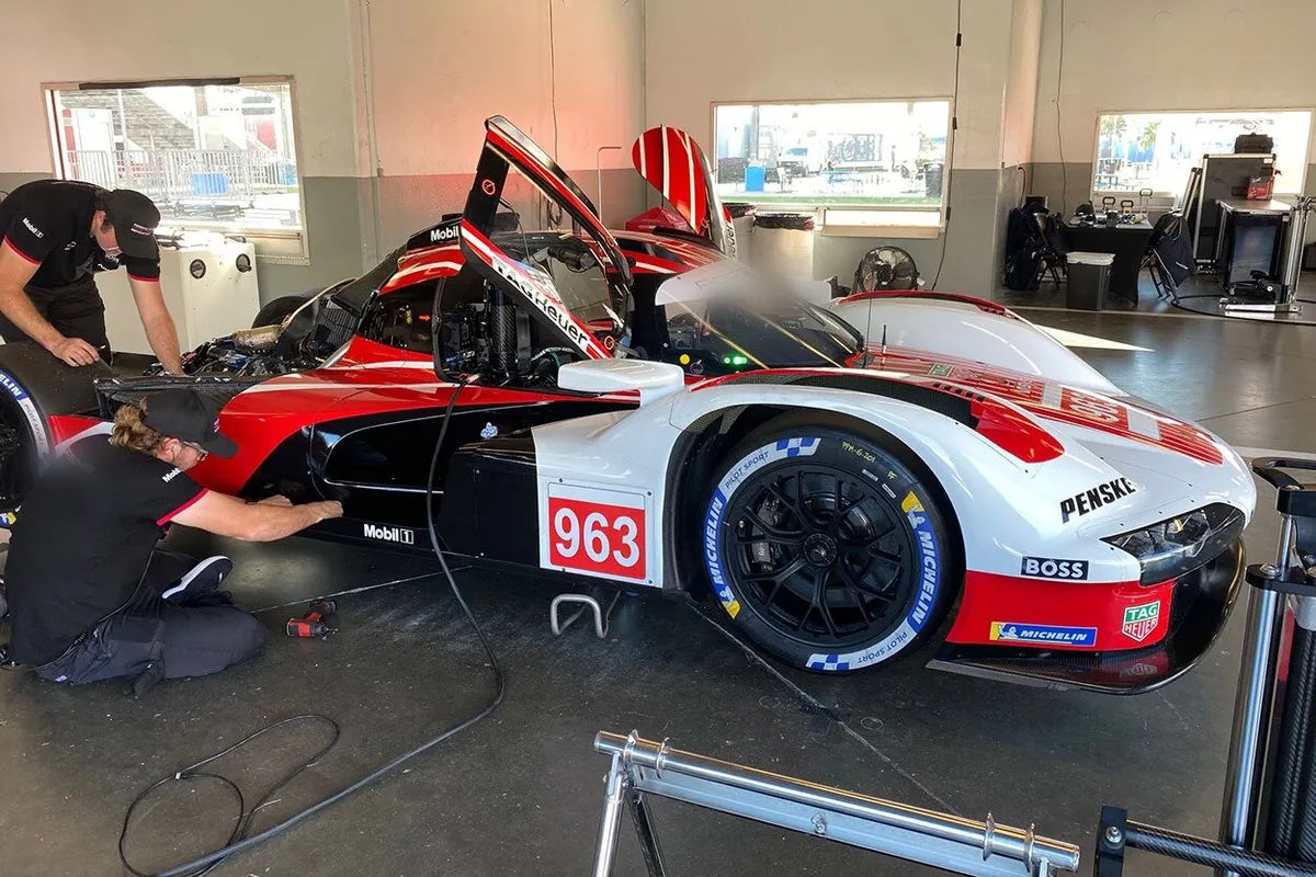 Une voiture de course d’endurance exposée dans un atelier.