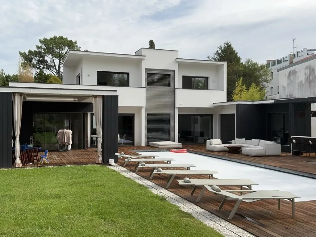 Une maison contemporaine avec jardin et piscine.